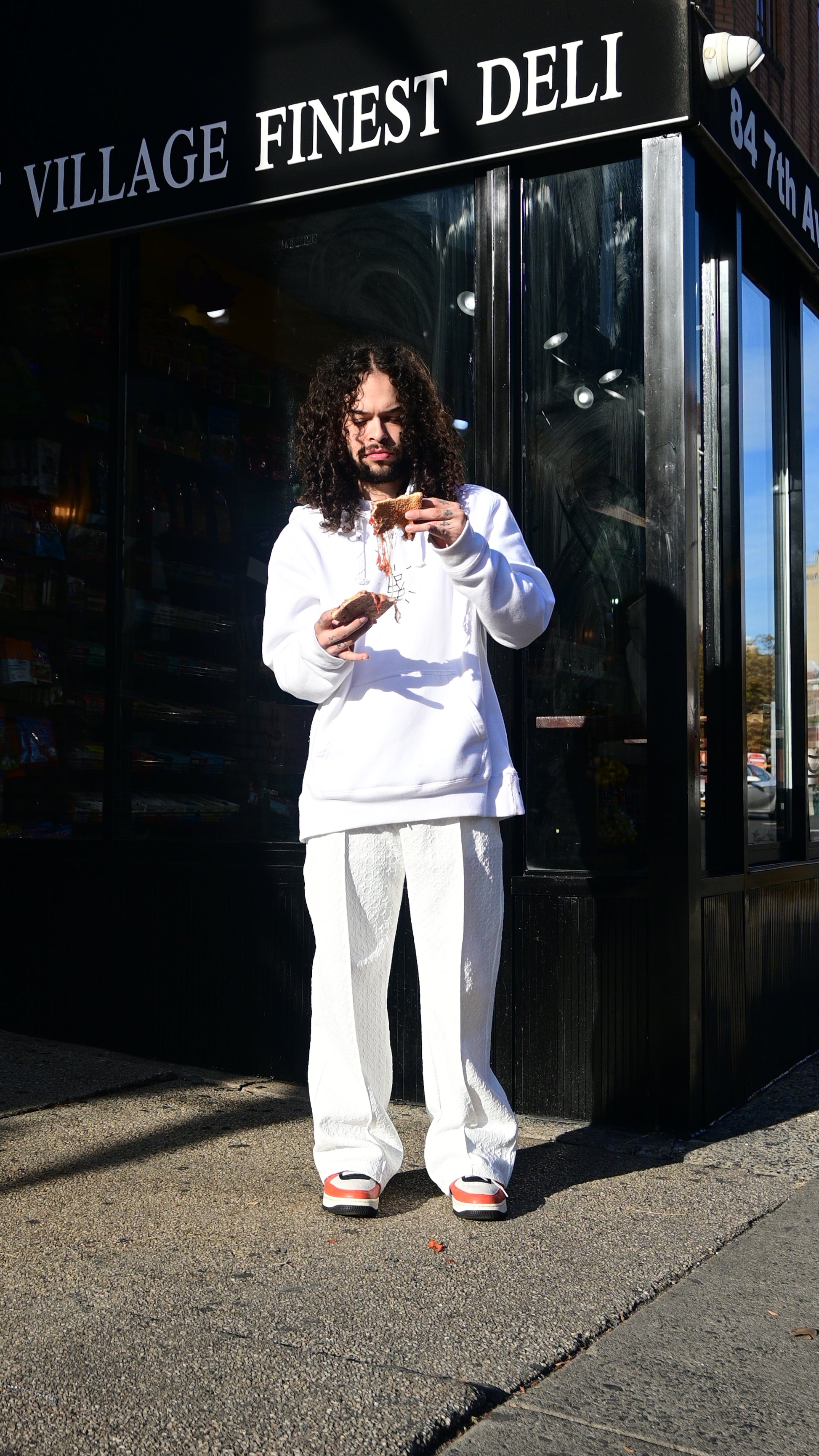 LV8R EATING PIZZA IN A WHITE HOCKEY STYLE LV8R HOODIE